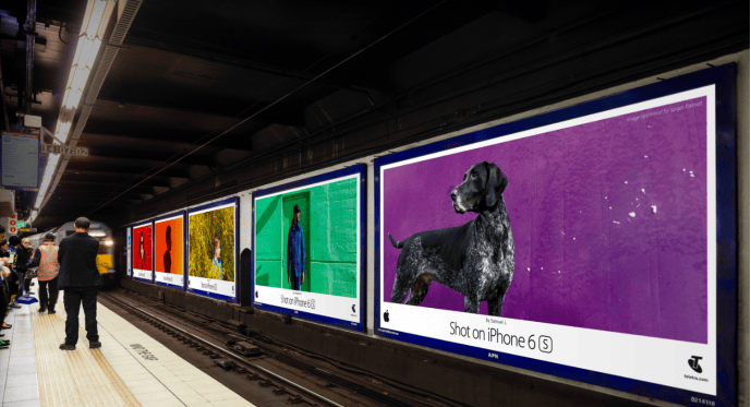 Image 1: Una piattaforma della metropolitana con annunci pubblicitari vivaci che mostrano immagini scattate con un iPhone 6S, esemplifica l'uso strategico di Apple del monitoraggio del ROI nel marketing. Ogni annuncio visivamente accattivante dimostra la qualità della fotocamera del telefono, attirando efficacemente l'attenzione dei pendolari e suscitando l'interesse per il prodotto, evidenziando il successo del ritorno sull'investimento (ROI) delle campagne pubblicitarie creative di Apple.