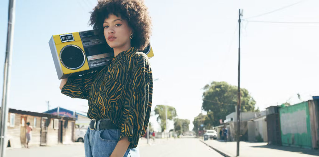 Image 1: Une femme tenant un boombox dans la rue, de l'agence d'achat d'espace radio.